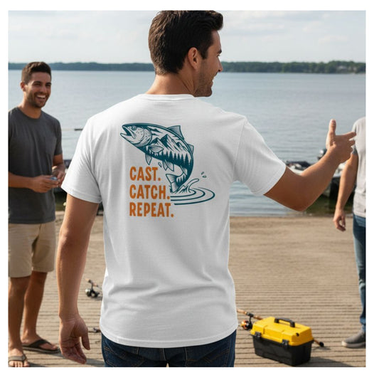 Man wearing a white t-shirt with a fish graphic and text by a lakeside.